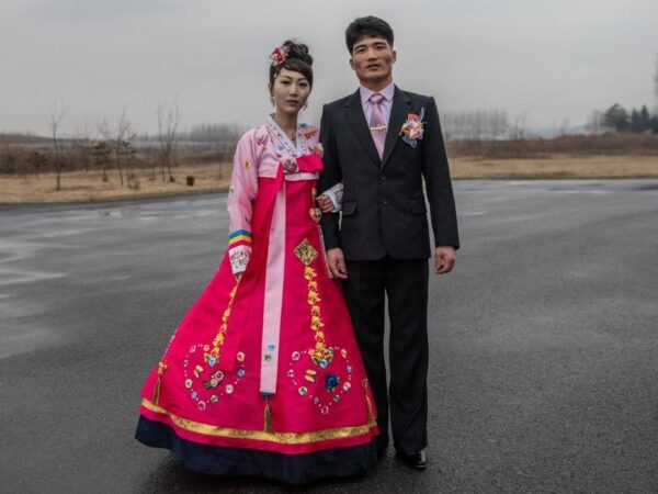 A North Korean bride wearing a traditional Korean hanbok wedding dress poses for a photograph with the groom as they arrive for a wedding party at Myrim Riding Club on February 06, 2019 in Pyongyang, North Korea