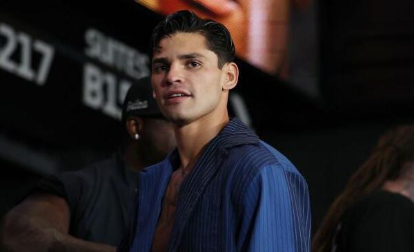 Ryan Garcia waits in a blue shirt at a weigh-in