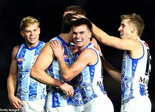 North Melbourne players celebrate their thrilling win over the Gold Coast Suns